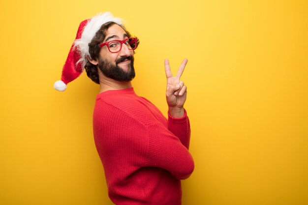 Hombre barbudo loco joven que lleva los vidrios rojos y el sombrero de Papá Noel