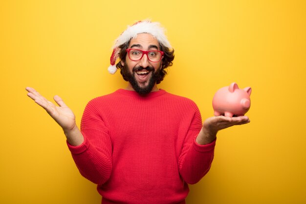 Hombre barbudo loco joven que lleva los vidrios rojos y el sombrero de Papá Noel