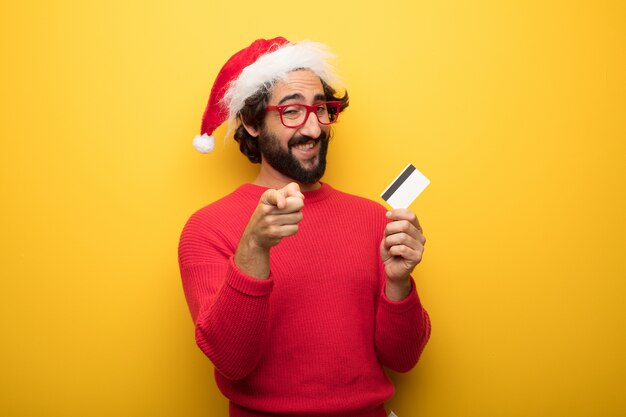 Hombre barbudo loco joven que lleva los vidrios rojos y el sombrero de Papá Noel