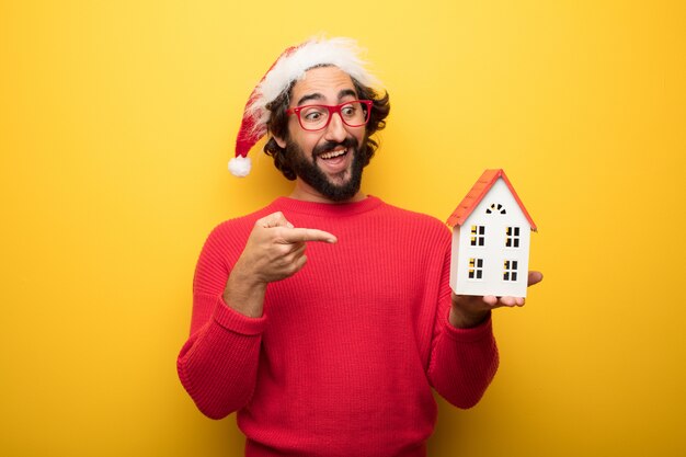 Hombre barbudo loco joven que lleva los vidrios rojos y el sombrero de Papá Noel