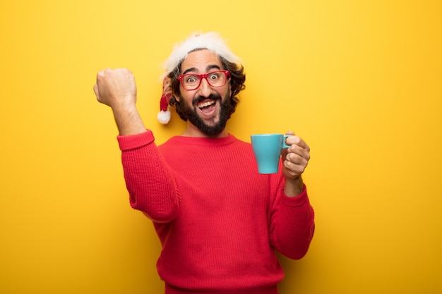 Hombre barbudo loco joven que lleva los vidrios rojos y el sombrero de Papá Noel