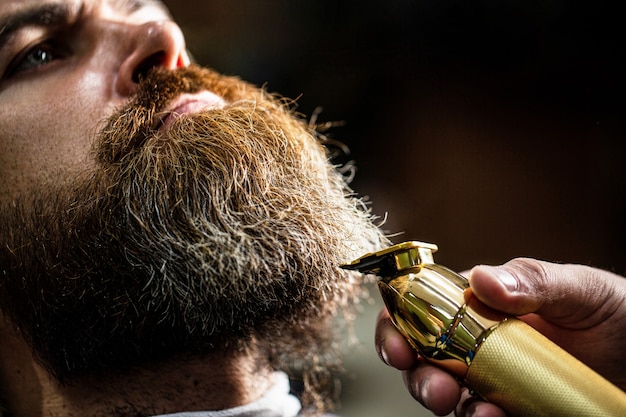 Hombre barbudo en peluquería. Hombre visitando estilista en peluquería