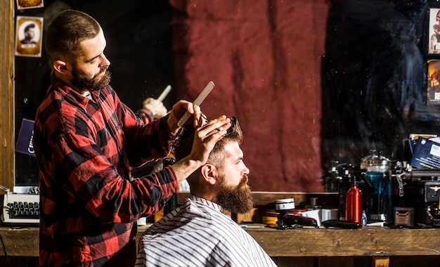 Hombre barbudo en peluquería. Trabaja en la peluquería. Peluquería corte de cabello de cliente masculino. Cliente de servicio de estilista en peluquería. Hombre visitando estilista en peluquería.