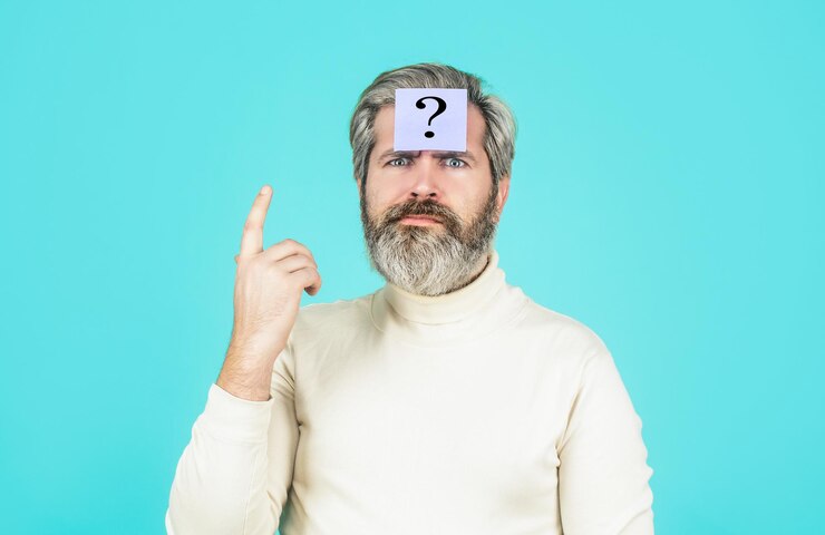 Foto hombre barbudo pensante con signo de interrogación sobre fondo azul notas de papel con signos de interrogación hombre barba signo de interrogación en problemas de solución de cabeza
