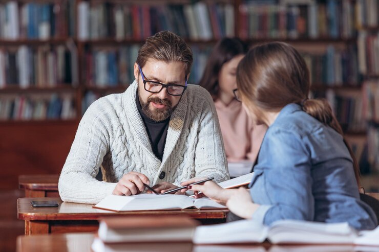 Hombre barbudo pidiendo ayuda estudiante en la biblioteca