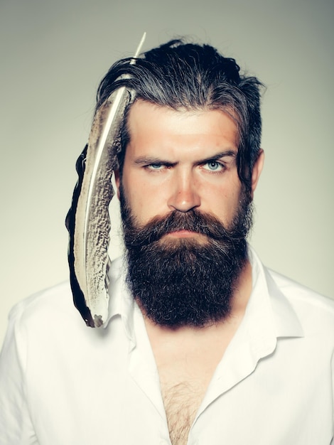 Hombre barbudo con pluma en el pelo