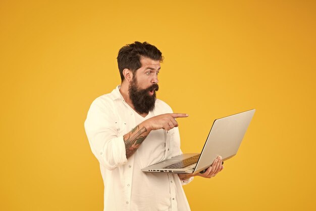 Hombre barbudo con portátil Compras en línea Hombre usando portátil Mundo digital Concepto de programación Programador con portátil Navegar por Internet En busca de inspiración Pago en línea Compra en línea