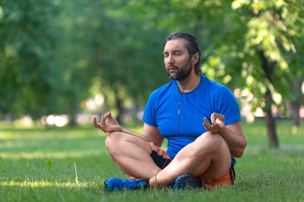 Hombre barbudo en posición de loto al aire libre