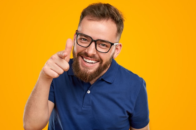 Hombre barbudo positivo en anteojos apuntando