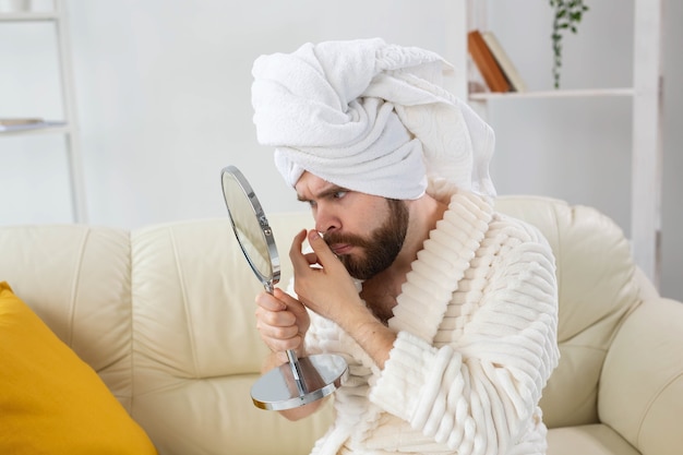 Hombre barbudo que controla su piel de la cara. Cuidado de spa, cuerpo y piel por concepto masculino.