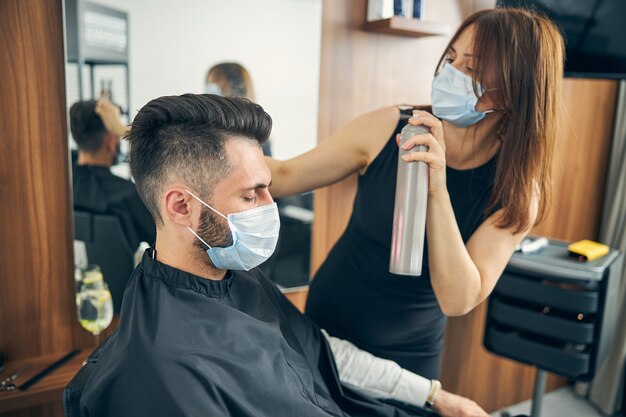 Hombre barbudo relajado sentado en posición semi y manteniendo los ojos cerrados mientras se prepara para la cita