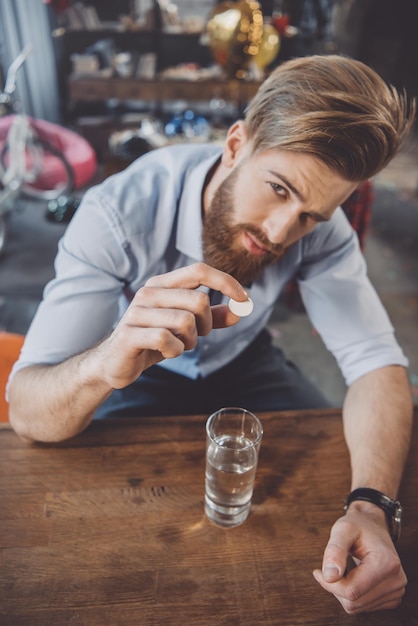 Foto hombre barbudo con resaca con medicamentos después de la fiesta en casa