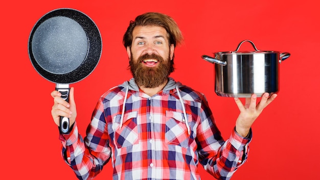 Hombre barbudo con sartén y olla sartén y cacerola utensilios de cocina para la preparación de alimentos