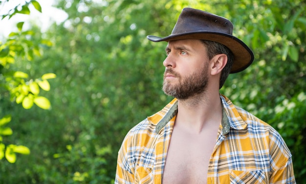Hombre barbudo con sombrero de vaquero hombre sexy con camisa a cuadros hombre occidental con sombrero