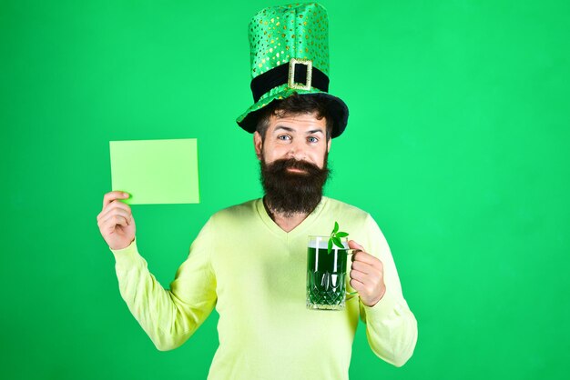 Hombre barbudo con sombrero verde tiene tablero verde día de san patricio feliz trébol de cuatro hojas sombrero verde con