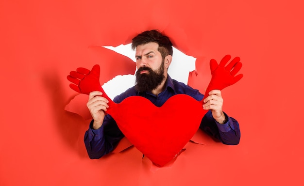 Hombre barbudo tiene corazón rojo amor día de San Valentín vacaciones celebrando concepto hombre romántico tiene