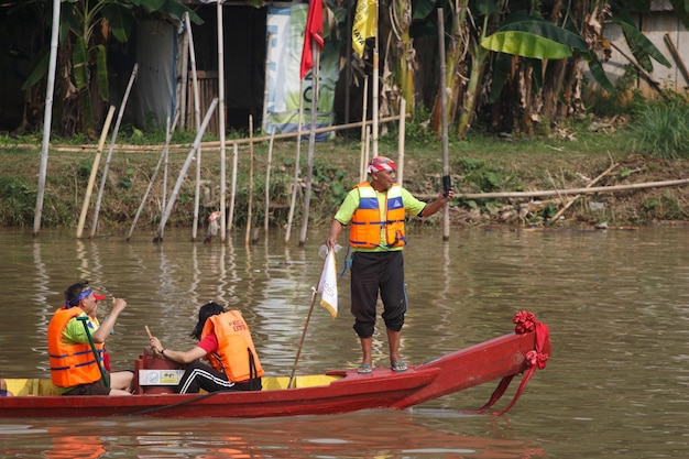 Un hombre en un barco con un chaleco salvavidas amarillo.