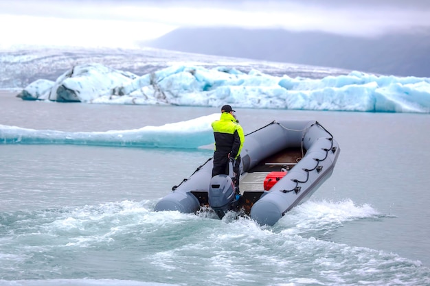 Hombre en un barco de motor rápido navegando por una laguna glaciar en Islandia