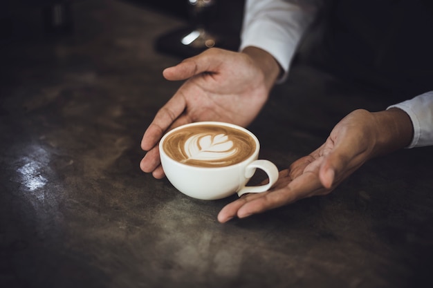 Hombre Barista preparando café para el cliente en la cafetería. Dueño del café que sirve a un cliente en la cafetería.