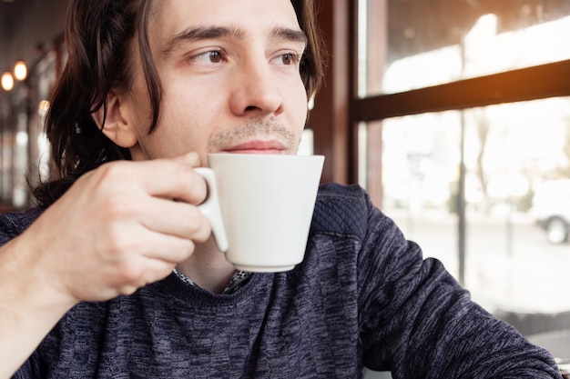 Un hombre bebe café en una cafetería, un restaurante