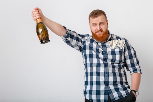 El hombre bebe champán de la botella