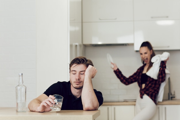 hombre bebe sentado en una mesa en la cocina