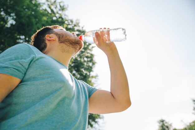 Foto hombre bebiendo agua en el caluroso día de verano copia espacio