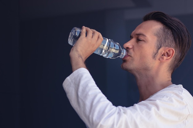 Hombre bebiendo agua en forma de botella