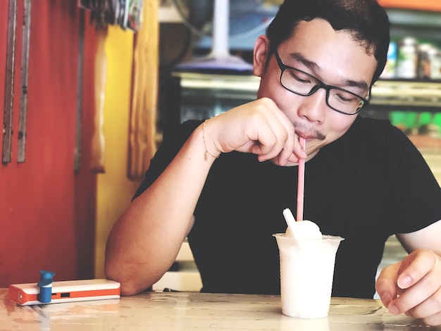 Hombre bebiendo batido en un restaurante