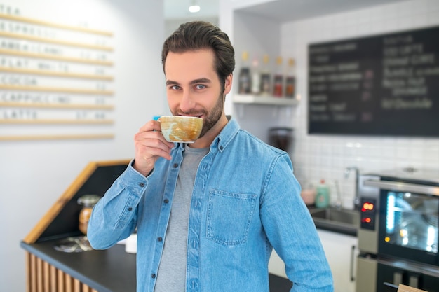 Foto hombre bebiendo café con confianza mirando a la cámara