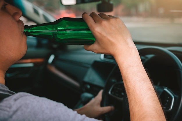 Foto hombre bebiendo cerveza mientras conduce un coche