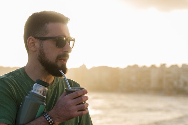 Foto hombre bebiendo chimarrao mate una infusión de yerba mate con ho