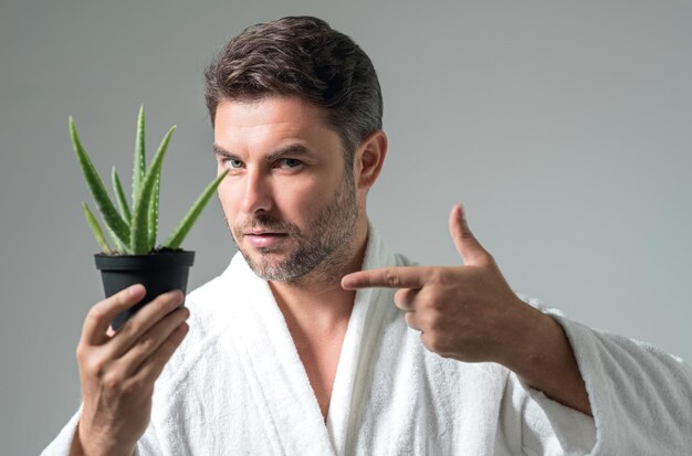 Foto hombre de belleza sostener aloe vera hombre de mediana edad con aloe vera aislado en el fondo del estudio aloe vera para