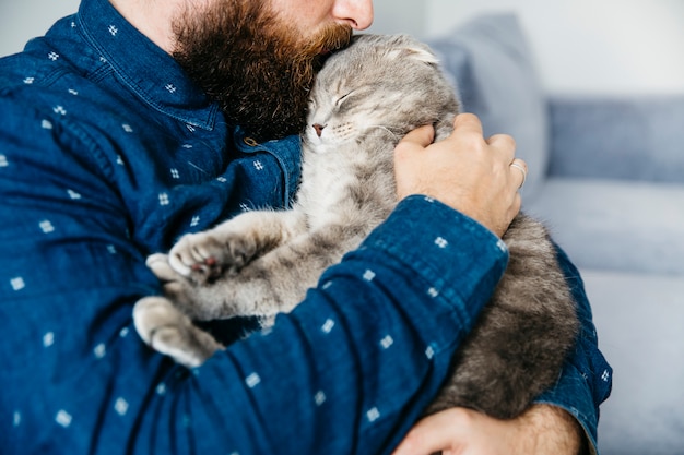 Foto hombre besándose adorable gato