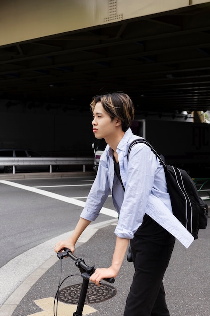 Foto hombre con bicicleta eléctrica en la ciudad