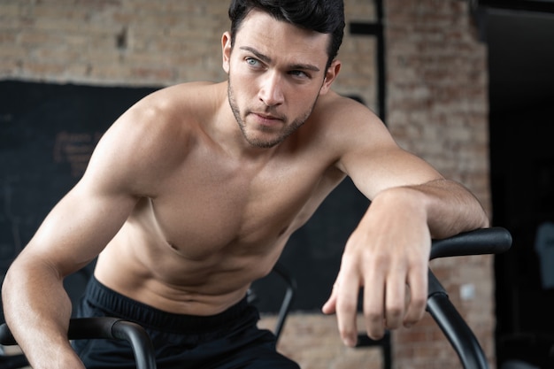 Hombre con bicicleta estática en el gimnasio. Hombre de fitness con bicicleta de aire para entrenamiento cardiovascular en el gimnasio de entrenamiento funcional.