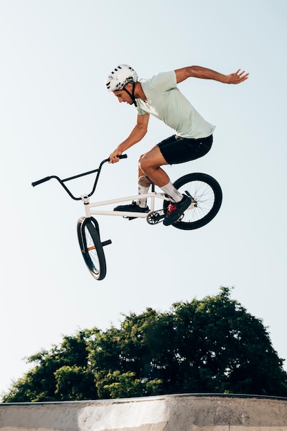 Foto hombre en bicicleta realizando trucos en skatepark