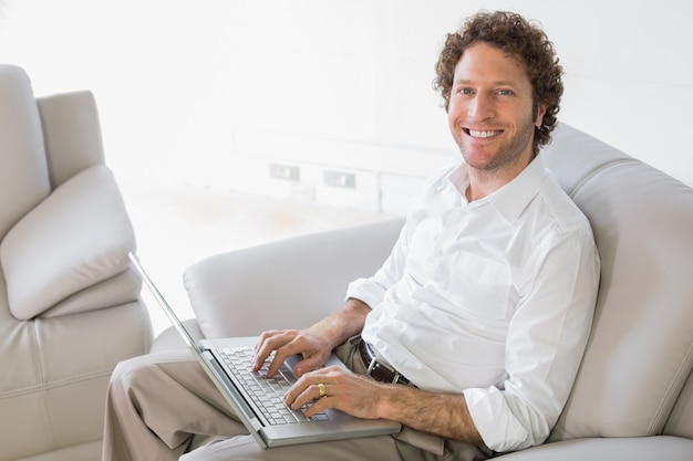 Hombre bien vestido usando laptop en casa