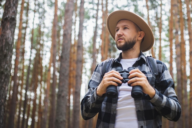 Hombre con binoculares en el bosque Caminata en las montañas o el bosque