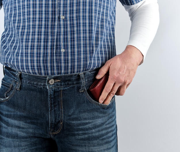 Hombre en blue jeans y una camisa a cuadros empuja