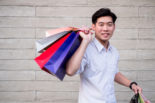 hombre con bolsa de compras Mira cámara y sonrisa, concepto de compras