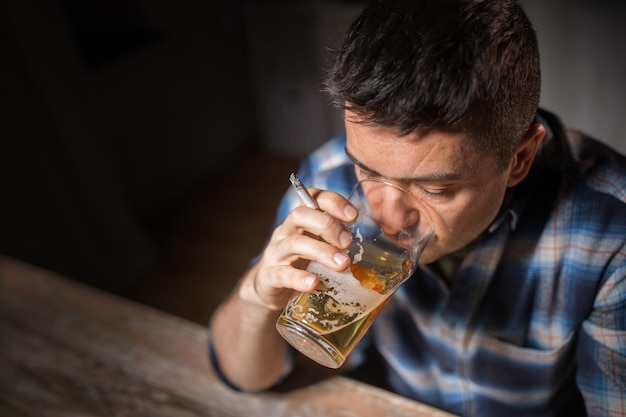 hombre borracho bebiendo alcohol y fumando cigarrillos