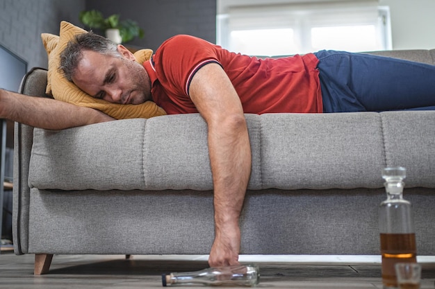 Hombre borracho durmiendo en un sofá
