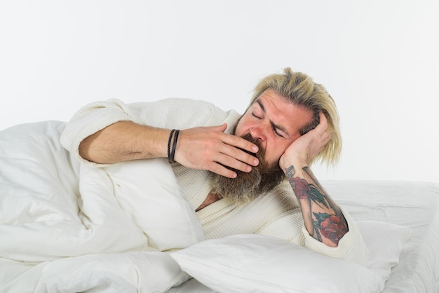 Hombre bostezo en la cama hombre barbudo en la cama por la mañana y despertar al hombre de la siesta durmiendo dulces sueños