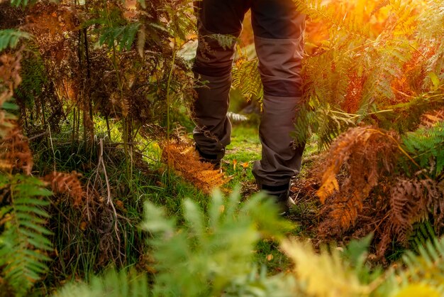 Hombre con botas caminando por las montañas llegando al destino y en la cima de la montaña en Peak