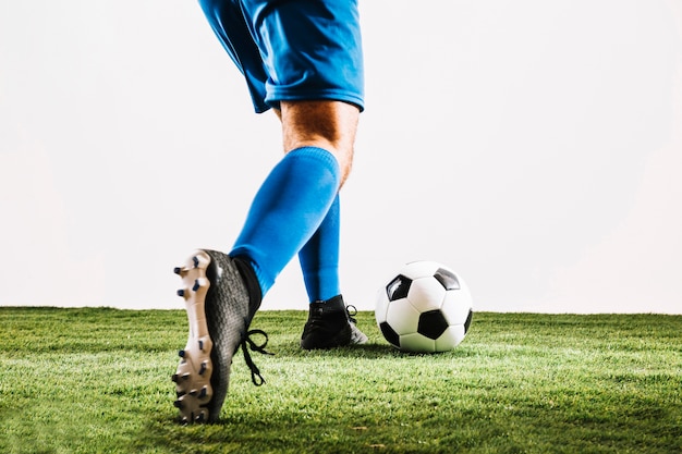 Foto hombre en botas de fútbol pateando la pelota