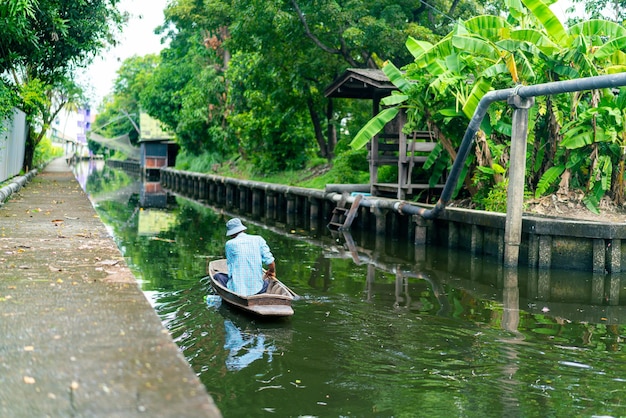 hombre bote de remos en el pequeño canal