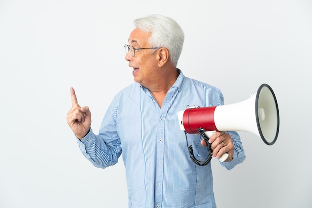 Hombre brasileño de mediana edad aislado sobre fondo blanco sosteniendo un megáfono y con la intención de darse cuenta de la solución