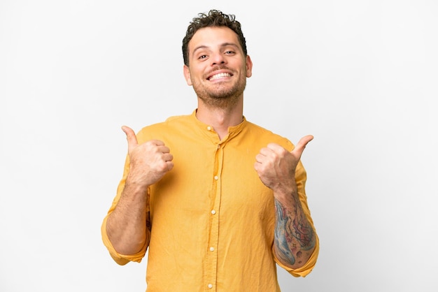 Hombre brasileño sobre fondo blanco aislado con pulgares arriba gesto y sonriendo