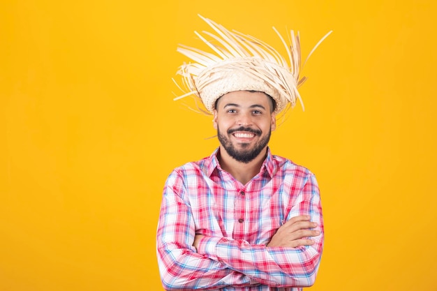 Hombre brasileño vestido con ropa típica de la Festa Junina con los brazos cruzados